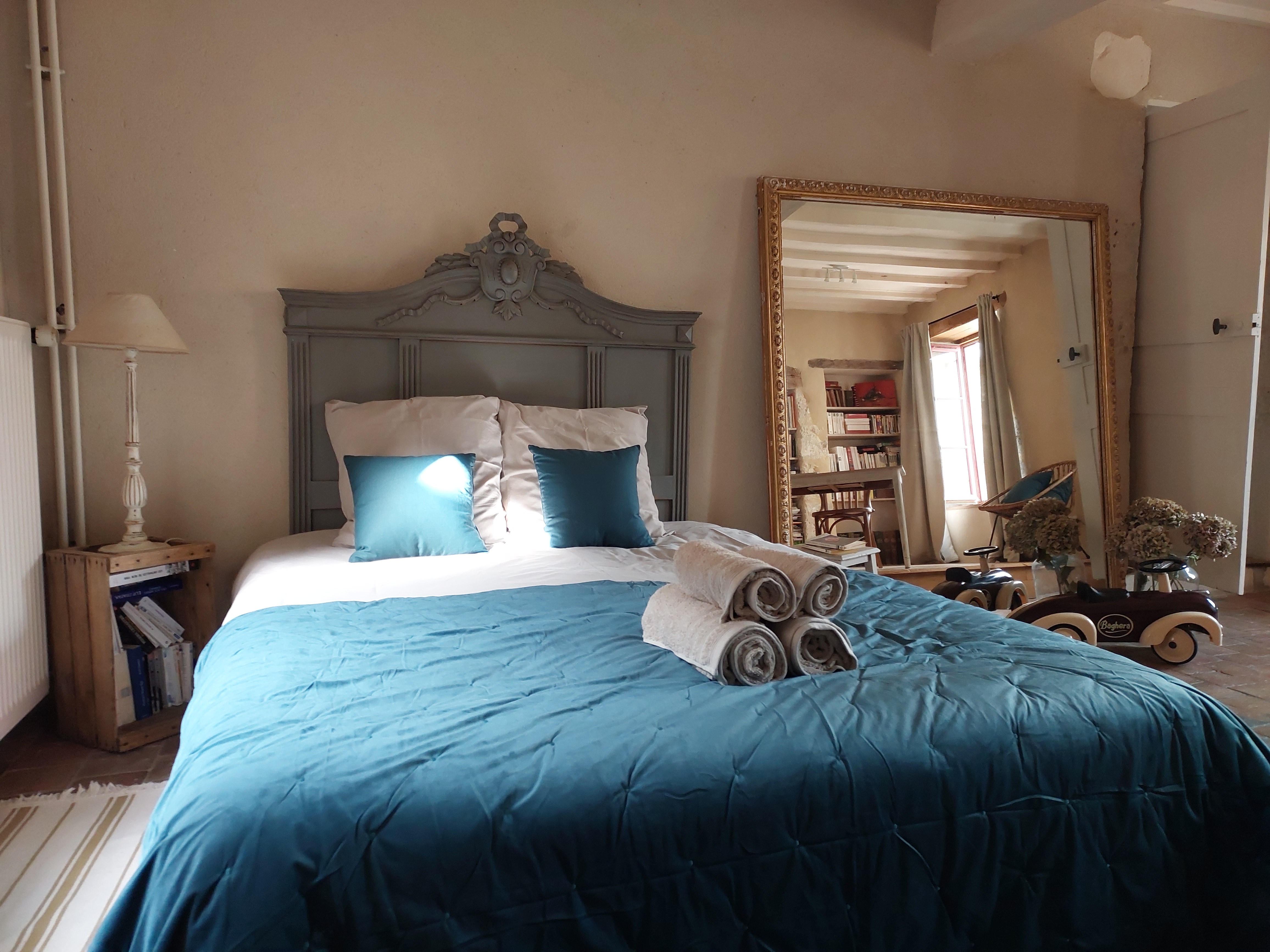 La chambre La Miroir, son grand miroir doré et son lit à dosseret