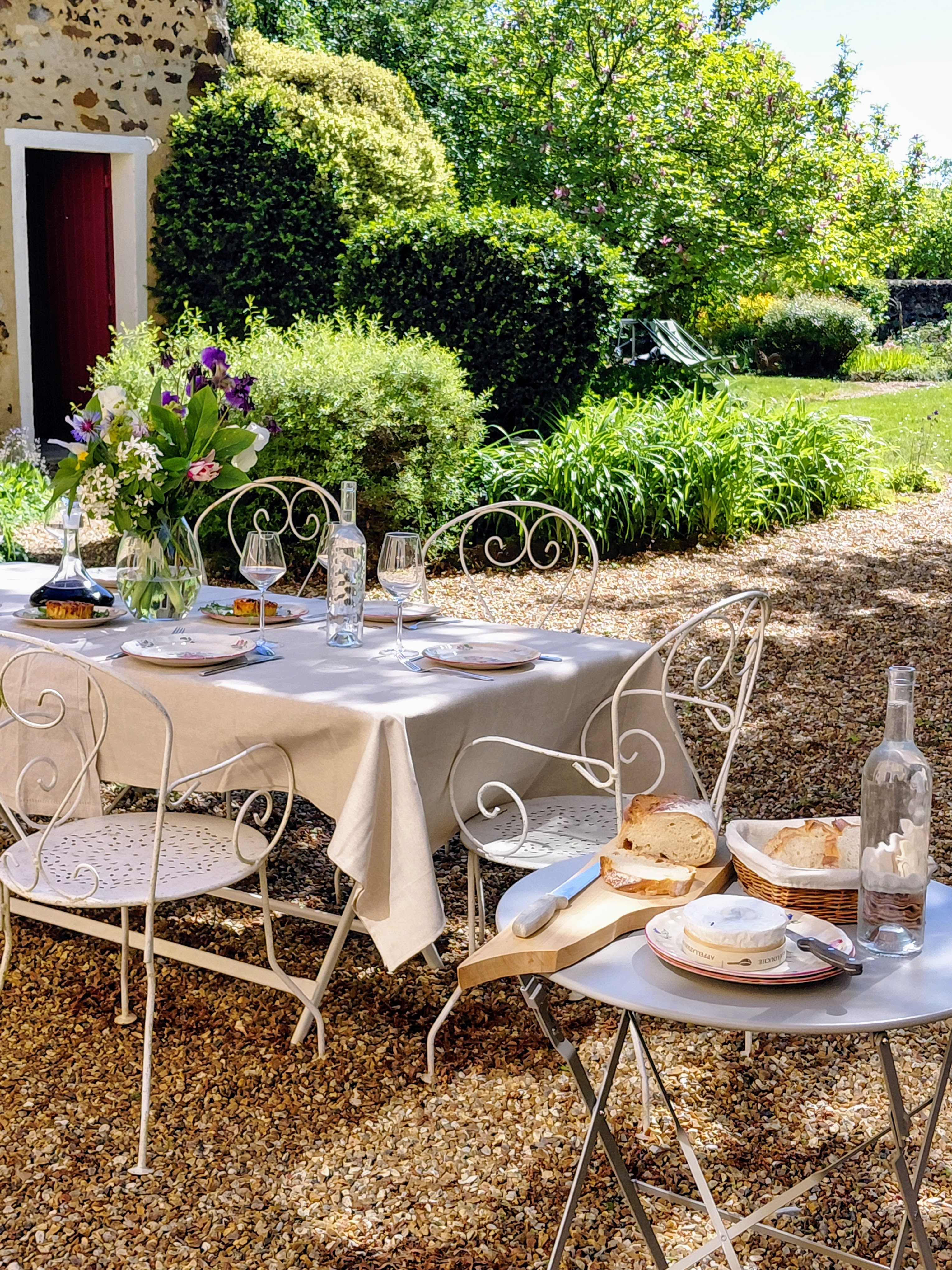 La grande table dressée au jardin, à l'ombre des arbres